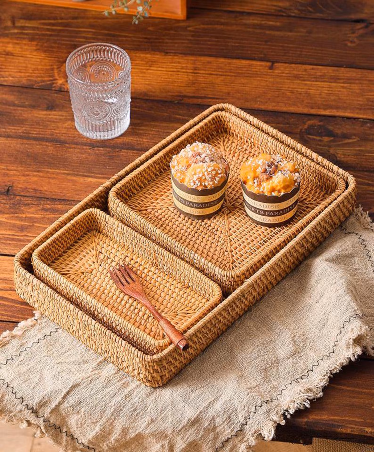 Three handwoven trays in small, medium, and large sizes, styled with small cakes